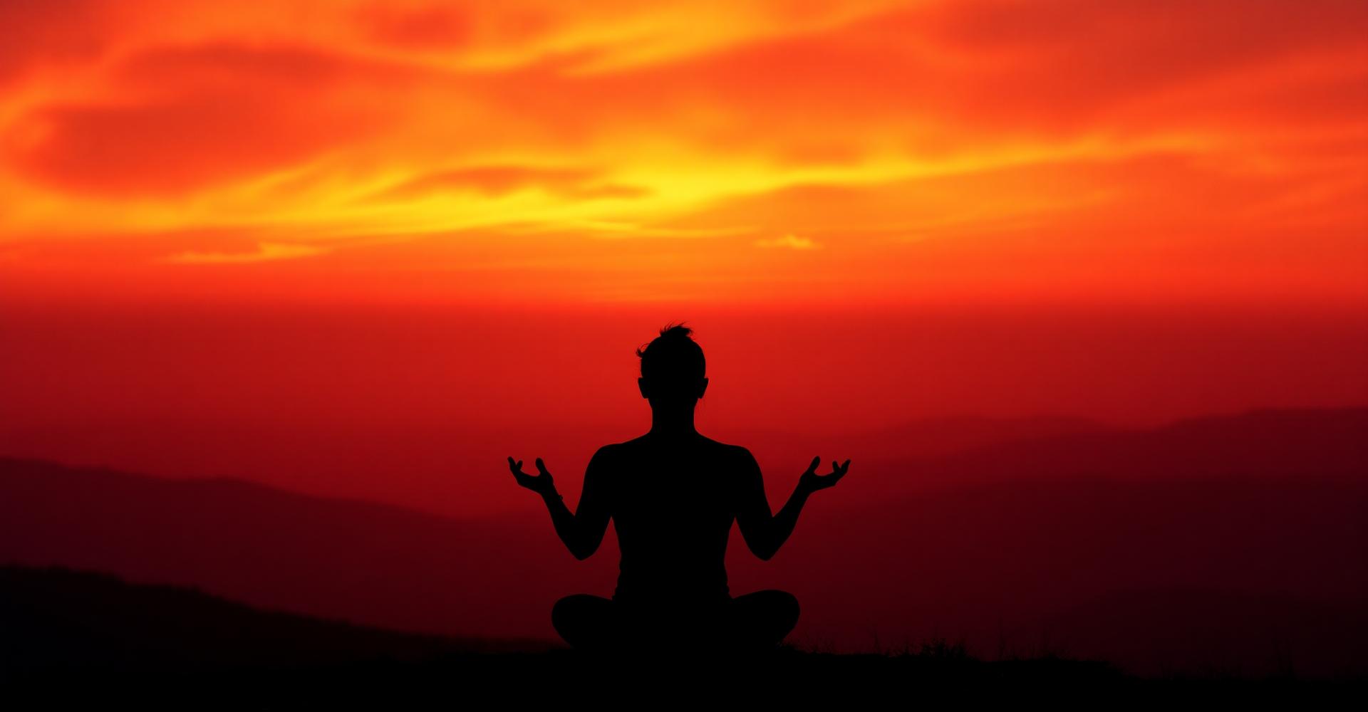 Gün batımında lotus pozunda meditasyon yapan bir siluet